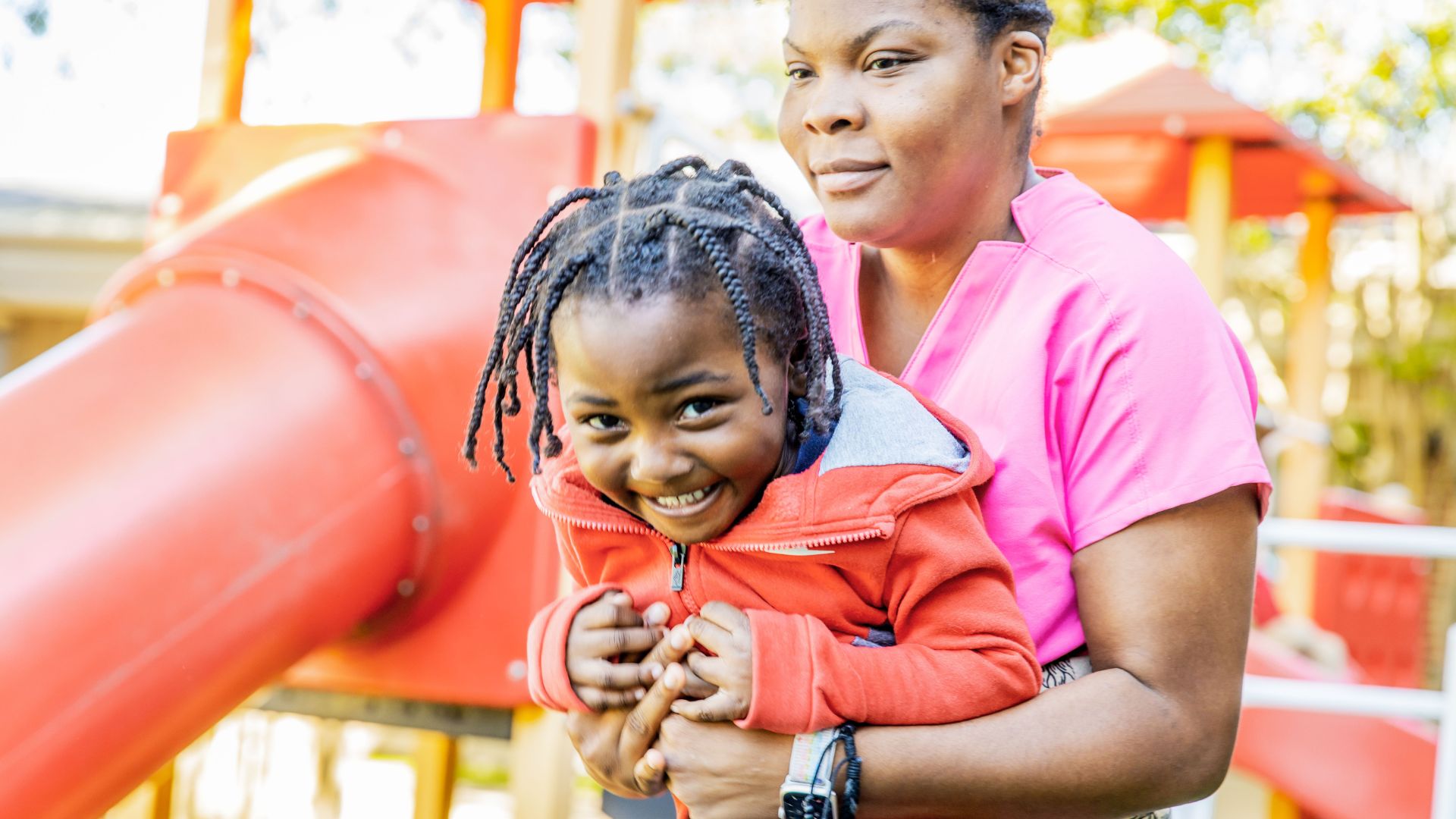 smiling woman and child on playground